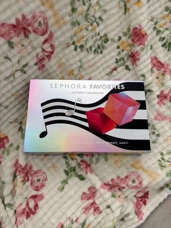 Calendrier Sephora Favorites posé sur un plaid fleuri